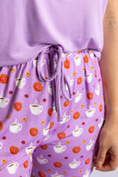 Woman wearing the Rest Day PJ But First Coffee lilac pyjama set, coffee and donut shorts print detail