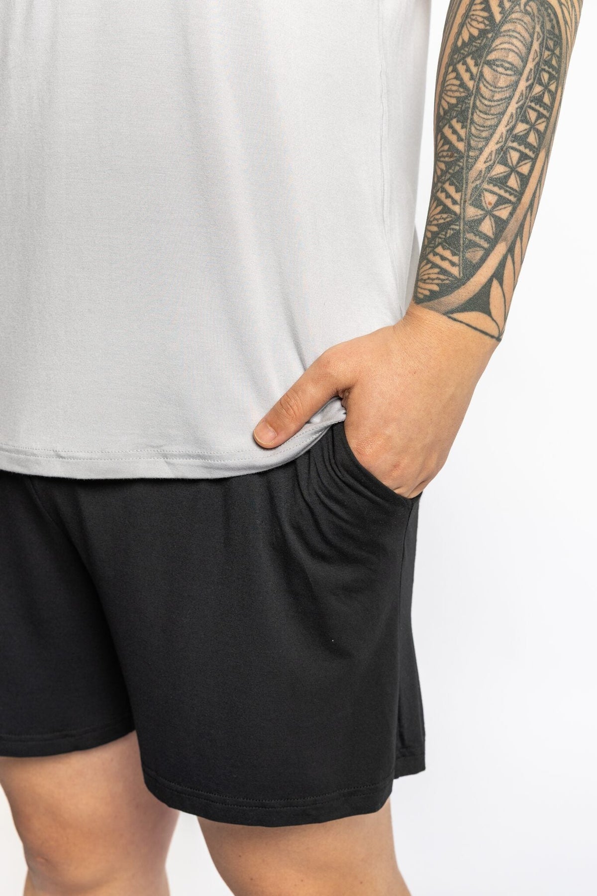 Man wearing the Rest Day PJ F.I.T. grey pyjama t-shirt and shorts set, side view with hands in pockets