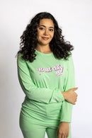 Model wearing the Rest Day PJ Signature green long-sleeve recovery pyjama set, front view