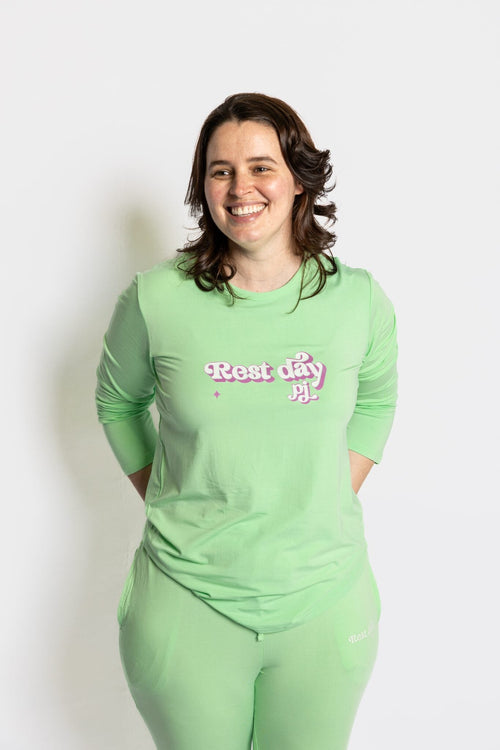 Model wearing the Rest Day PJ Signature green long-sleeve recovery pyjama set,