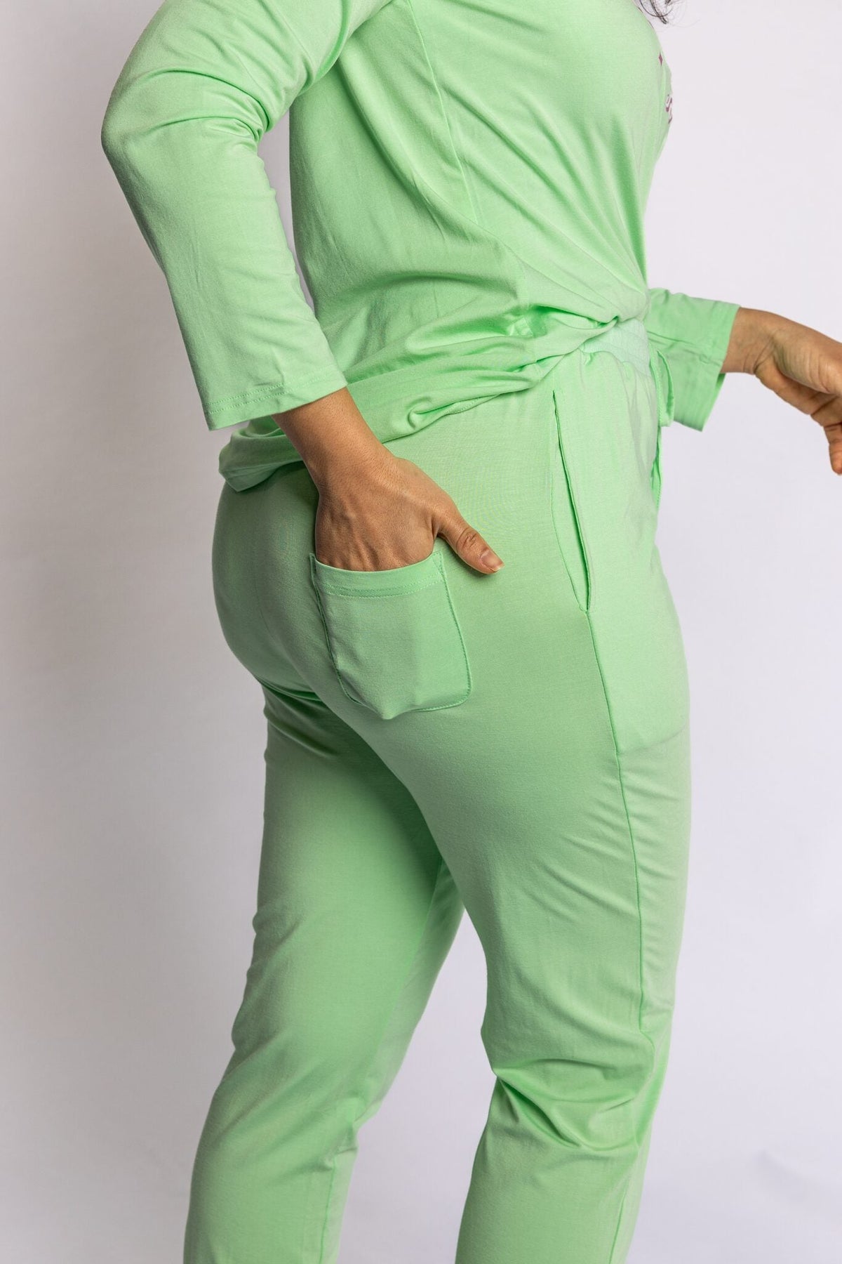 Model wearing the Rest Day PJ Signature green long-sleeve recovery pyjama set, back pocket detail