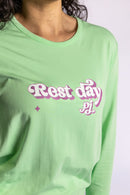 Model wearing the Rest Day PJ Signature green long-sleeve recovery pyjama set, close-up of the Rest Day PJ logo