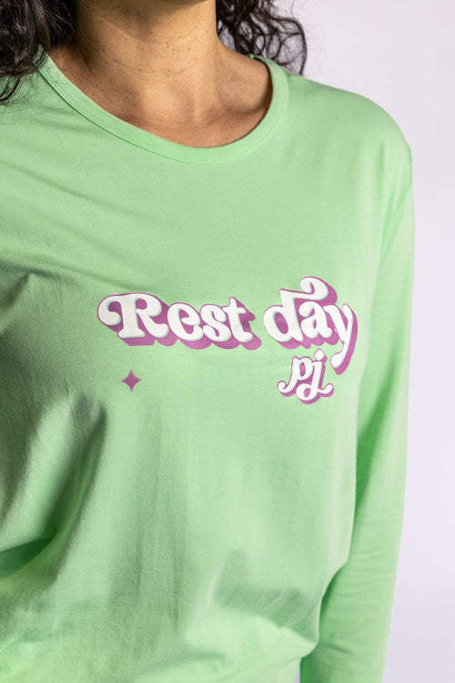 Model wearing the Rest Day PJ Signature green long-sleeve recovery pyjama set, close-up of the Rest Day PJ logo