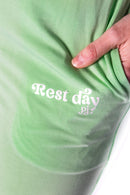 Model wearing the Rest Day PJ Signature green long-sleeve recovery pyjama set, close-up of the Rest Day PJ logo